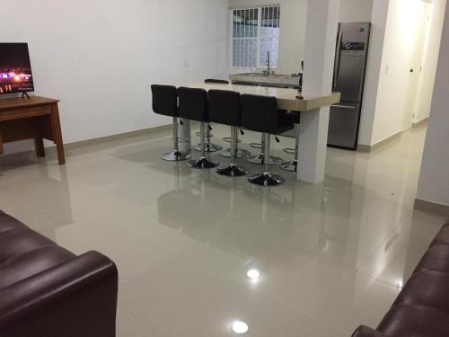 a kitchen with a counter with stools and a sink at Linda casa 12 Malecon Central Park Acuario in Mazatlán
