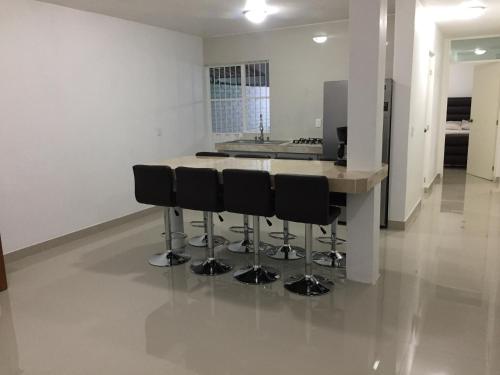 a kitchen with a island with black bar stools at Linda casa 12 Malecon Central Park Acuario in Mazatlán