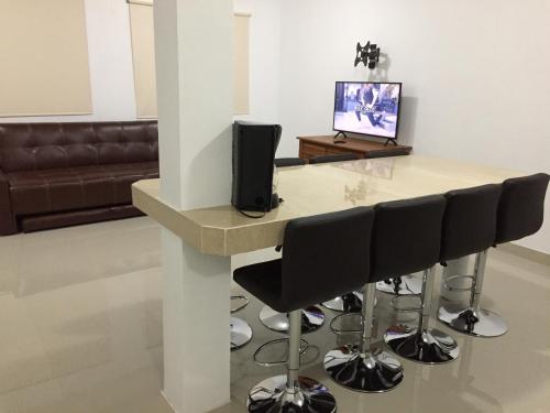 a living room with a table with chairs and a television at Linda casa 12 Malecon Central Park Acuario in Mazatlán