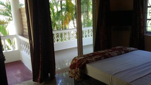 a bedroom with a bed and a window at Victoria Villa in Sinquerim