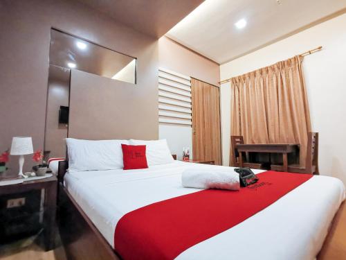 a bedroom with a large bed with a red blanket at Reddoorz Plus near Robinsons Place Gensan in General Santos