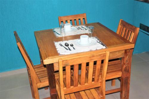 a wooden table with two chairs and a table with a plate at Residencial Águas de Bare in São Sebastião
