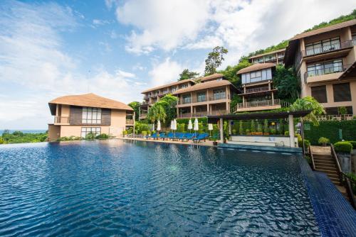 a swimming pool in front of a resort at Karon Phunaka Resort in Karon Beach