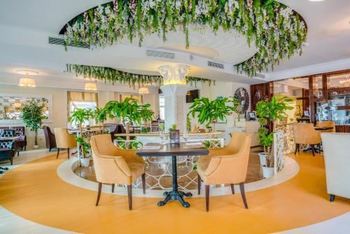 - un hall avec des chaises et une table ornée de plantes dans l'établissement Sadovnicheskaya Suites, à Moscou