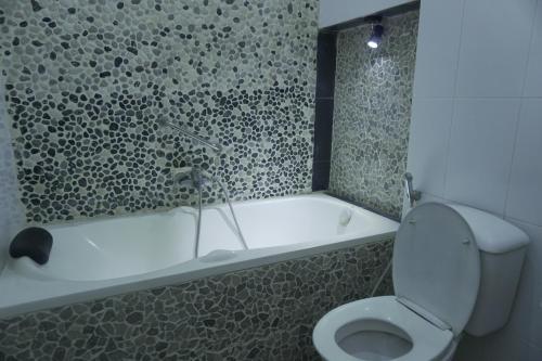 La salle de bains est pourvue de toilettes et d'une baignoire. dans l'établissement Sayana Homestay, à Sleman
