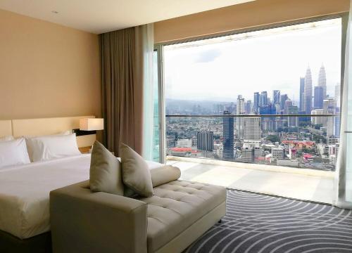 a hotel room with a bed and a large window at Upper View Regalia Hotel Kuala Lumpur in Kuala Lumpur