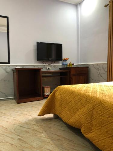 a bedroom with a bed and a flat screen tv at Binh Minh Dien Chau Hotel in Diễn Châu