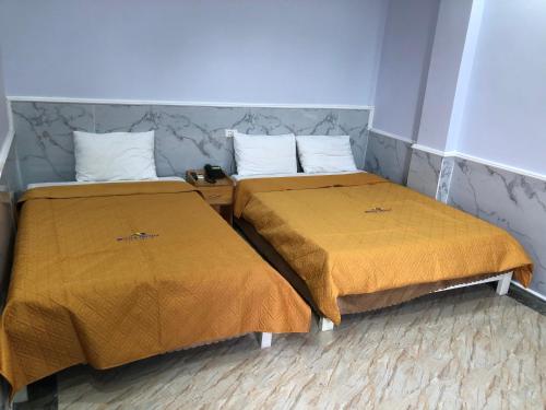 two beds sitting next to each other in a room at Binh Minh Dien Chau Hotel in Diễn Châu