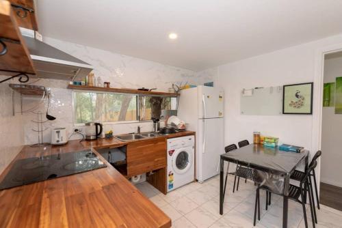a kitchen with a table and a sink and a stove at 1 Private Double Room In Carramar 1-minute to Station - ROOM ONLY in Sydney