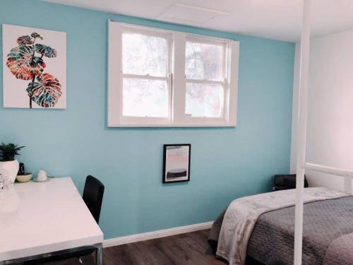 a bedroom with a blue wall with a bed and a window at 1 Private Double Room In Carramar 1-minute to Station - ROOM ONLY in Sydney