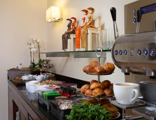 a breakfast buffet with bread and pastries on a counter at Nevo by Isrotel Collection in Ein Bokek