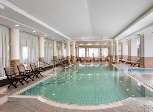 a pool in the middle of a building with chairs at Nevo by Isrotel Collection in Ein Bokek