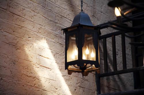 a black lantern hanging on a brick wall at Yangshuo Village Inn Boutique Hotel in Yangshuo
