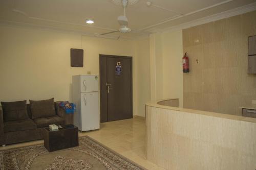 a living room with a couch and a refrigerator at Al Eairy Apartment-Alqaseem 4 in Buraydah