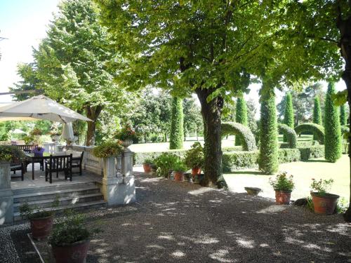 a garden with a table and chairs under a tree at Villa Verganti Veronesi in Inveruno