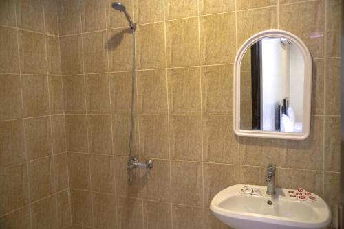 a bathroom with a shower with a sink and a mirror at Al Eairy Apartment-Alqaseem 4 in Buraydah