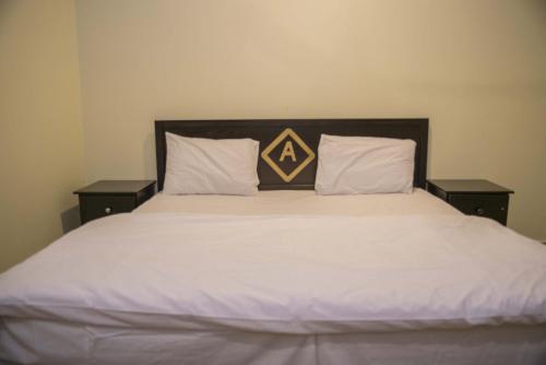 a large bed with two pillows on top of it at Al Eairy Apartment-Alqaseem 4 in Buraydah