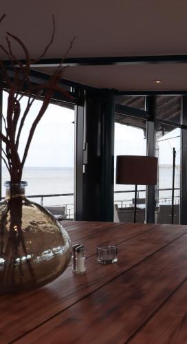 a wooden table with a vase on top of it at Hotel & Restaurant Utkiek in Greifswald