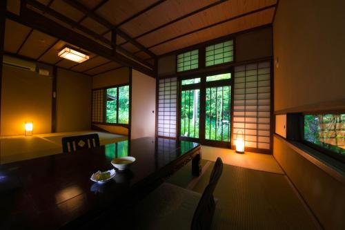 a dining room with a table and two windows at Yufuin Gettouan in Yufu