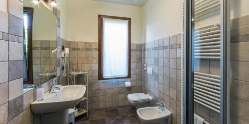 a bathroom with a sink and a toilet and a mirror at Agriturismo Le Case Di Campagna in Dossobuono