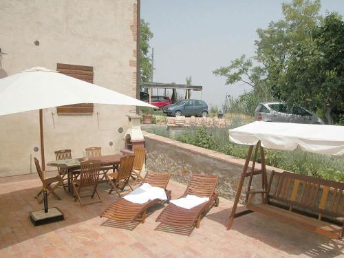 a patio with a table and chairs and an umbrella at Podere Le Grotte in San Gimignano