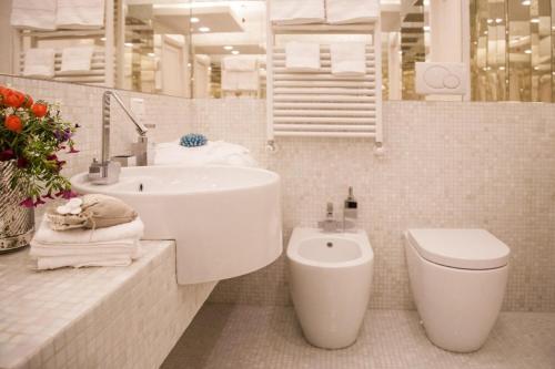 a white bathroom with a sink and a toilet at Villa Verganti Veronesi in Inveruno