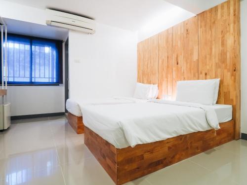 a bedroom with a large bed with a wooden headboard at Loyy Hotel in Chiang Mai