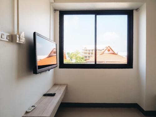 a living room with a tv and a window at Loyy Hotel in Chiang Mai