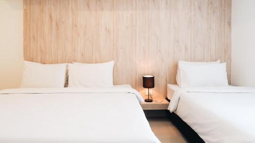 two beds sitting next to each other in a room at Loyy Hotel in Chiang Mai