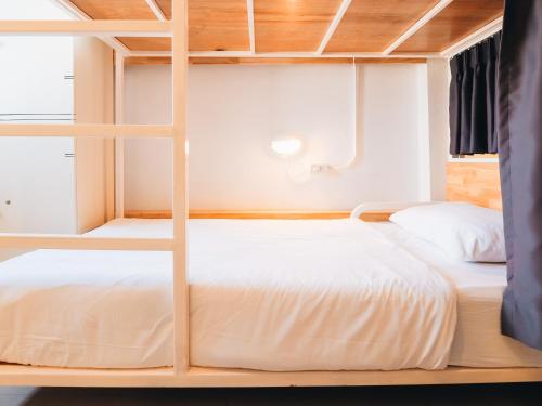 a bedroom with two bunk beds and a window at Loyy Hotel in Chiang Mai