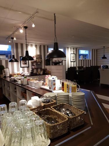 a restaurant with a counter with dishes and glasses at Huskvarna Hotell & Vandrarhem in Huskvarna
