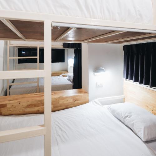 a bunk bed in a room with two beds at Loyy Hotel in Chiang Mai