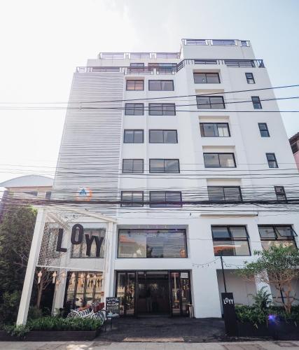 a tall white building with a sign on it at Loyy Hotel in Chiang Mai