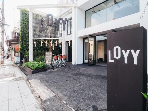 a building with a joy sign in front of it at Loyy Hotel in Chiang Mai
