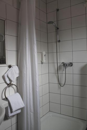 a bathroom with a shower with a shower curtain at Alleehotel-Eschen in Aurich