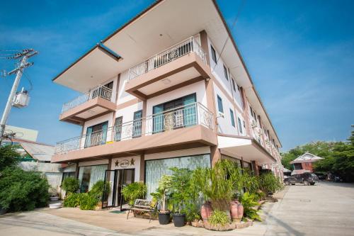 a tall pink building with balconies and plants at The Star Hotel in Udon Thani