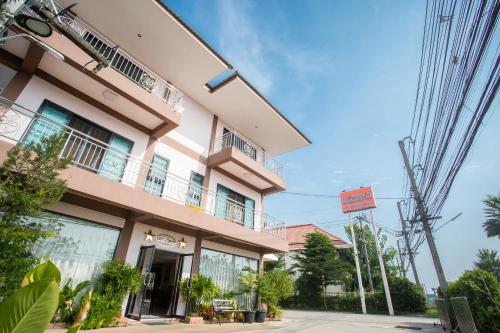 a pink building with a balcony on a street at The Star Hotel in Udon Thani