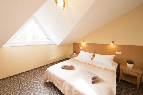 1 dormitorio con 1 cama grande y 2 toallas. en Hotel Vita en Druskininkai