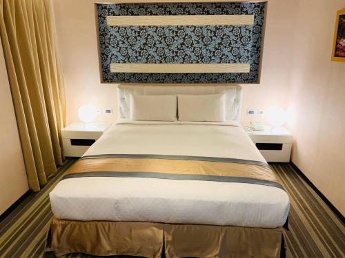 a bedroom with a large bed with two night stands at Kaishen Sinsu Hotel in Taitung City