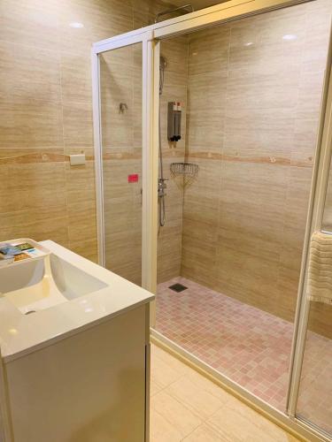 a bathroom with a shower with a sink and a basketball hoop at Kaishen Sinsu Hotel in Taitung City