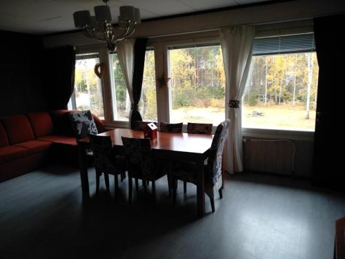 a dining room with a table and chairs and a couch at Cottage Viardo in Vehkataipale