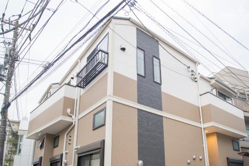 um edifício com linhas eléctricas por cima em Cozy Vibes Apt Hotel em Tóquio