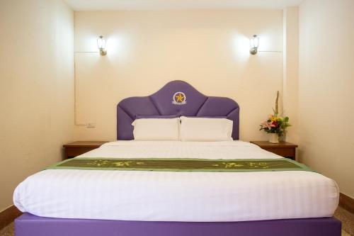 a bed with a purple headboard in a room at The Star Hotel in Udon Thani