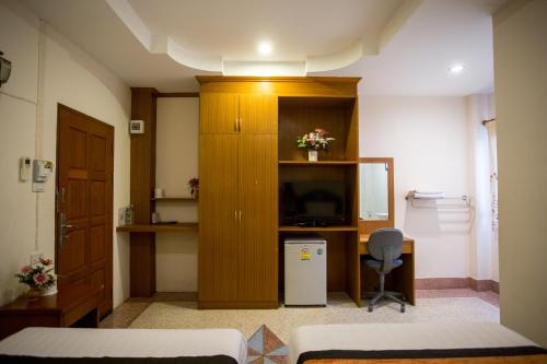 a room with a bed and a television and a desk at The Star Hotel in Udon Thani