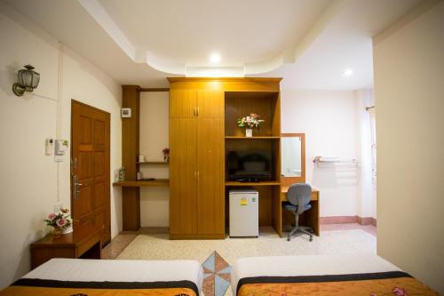 a small room with two beds and a television at The Star Hotel in Udon Thani