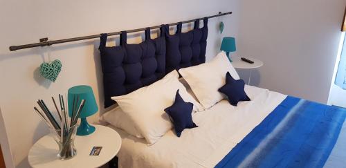1 dormitorio con 1 cama con almohadas azules y blancas en B&B Isolatiberina en Roma