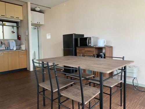 a kitchen with a table and chairs in a room at Big Stone Tsukuda 45平米 2SDbed 2For3F in Aomori