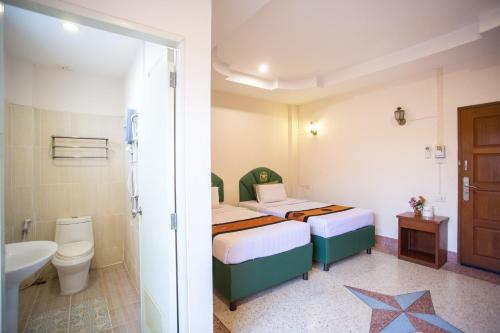 a bedroom with two beds and a toilet and a sink at The Star Hotel in Udon Thani