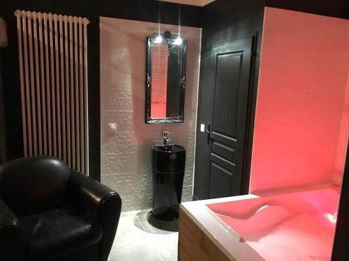 a black room with a black chair and a pink sink at Matin de Saône in Fontaines-Saint-Martin