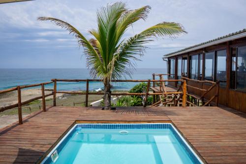 a swimming pool on a deck with a view of the ocean at C-Mew Guest House in Praia do Tofo